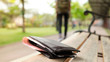 Leather purse with a money lying on the park bench while tourists are walking away. - image