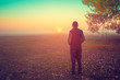 © vvvita - A man stands in the field early in the morning and looks at the sunrise