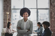 © ReeldealHD images - Portrait of smiling businesswoman with afro hair standing in office