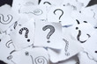 Many question marks on white papers. Doodle drawn question marks on scraps of paper. Choice, decision making, assortment concept