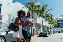 USA, Florida, Miami Beach, Happy Young Couple Crossing The Street