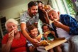 Multi-generation family eating pizza together