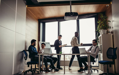 Wall Mural - Business people in an open space office interior with a panoramic window