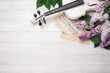 A bouquet of lilacs with violin and music sheet on a white wooden table. Top wiev with space for your text.