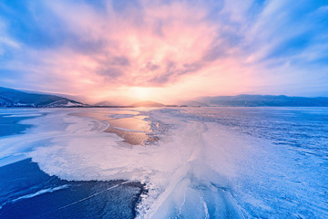 frozen surface of baikal lake at sunset.