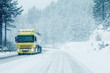Traffic truck on winter road in snow blizzard