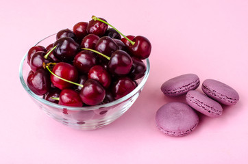 Wall Mural - Glass bowl with cherry on pink background