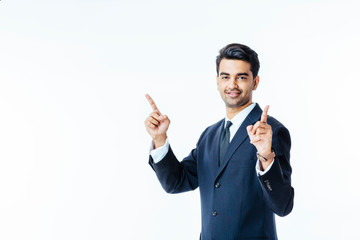 Portrait of a handsome, smiling man in business suit and tie pointing and up with both fingers, isolated on white studio background