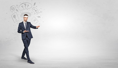 Young businessman in suit fighting with doodled symbols concept
