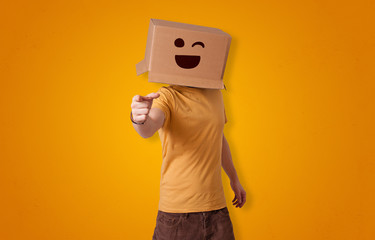 Funny man wearing cardboard box on his head with smiley face
