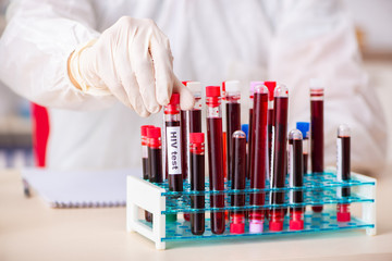 Young handsome lab assistant testing blood samples in hospital 