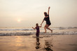 © yurakrasil - happy family at the beach. mother hugging child daughter and fly tourism with children