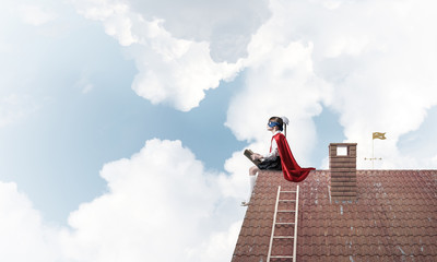 Girl power concept with cute kid guardian against cloudscape bac