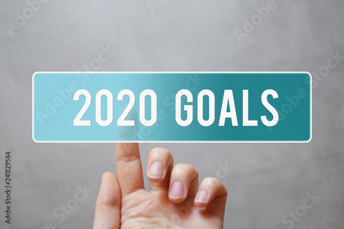 Fotografia 2020 goals - finger pressing blue transparent button on virtual touchscreen interface on gray background with copy space for text
