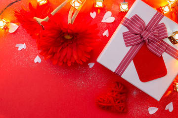 Wall Mural - Gift, red gerberas and a heart on a red background.