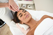 © javiindy - Woman receiving head massage in spa wellness center.