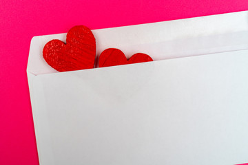 Two red hearts in a white envelope.