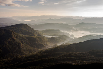 Canvas Print - View over mountain from a mountain peak. Panorama view over mountains and lake. Misty morning just after sunrise. Nature landscape.