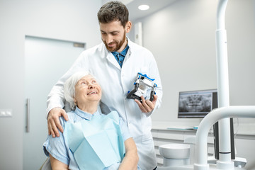 Lovely portrait of a dentist hugging elder woman patient in the dental office