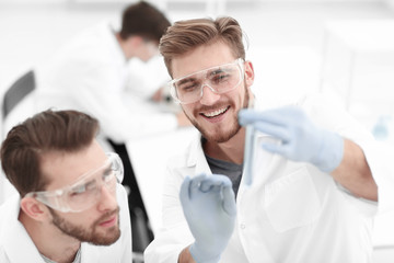 Wall Mural - two biologist examining liquid in a test tube