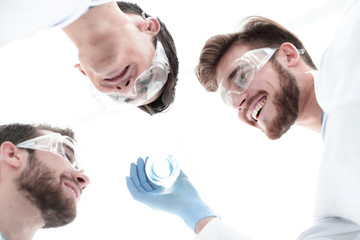 Wall Mural - closeup.a group of scientists looks at the liquid in the beaker