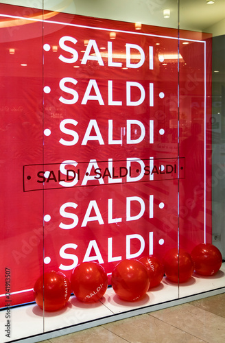 Fotografía the window of an Italian shop, with a big red sign and balloons with the word sale repeated many times