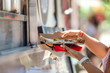 Close-up of woman's hands holding a slice of pizza on a food truck