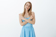 © Cookie Studio - Make choice wisely. Portrait of relaxed and friendly good-looking blond girl in blue dress crossing hands on body as pointing sideways, presenting products to left and right of copy space, smiling