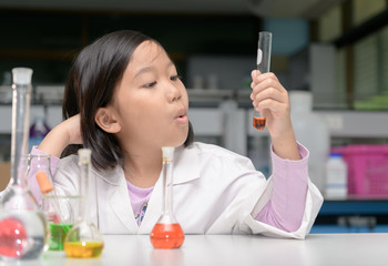 Wall Mural - happy little scientist in lab coat making experiment