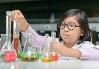 Wall Mural - little scientist in lab coat making experiment