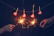 Couple holding a burning sparklers with valentine background concept.