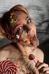 Wall Mural - Girl with sweets and caramel on her face shot