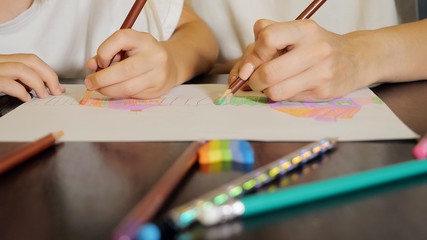 Woman with little girl drawing on paper