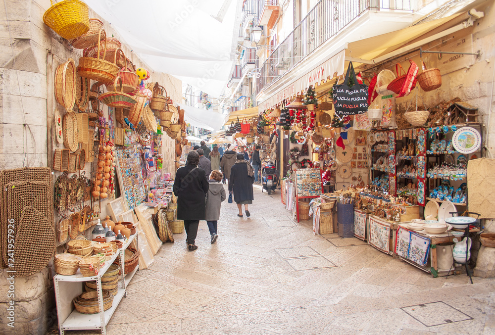 View of a narrow street in  Bari, Puglia, Italy, Bari vecchia, traditional open market shops with souvenir for tourists - obrazy, fototapety, plakaty 