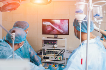 Wall Mural - Process of gynecological surgery operation using laparoscopic equipment. Group of surgeons in operating room with surgery equipment