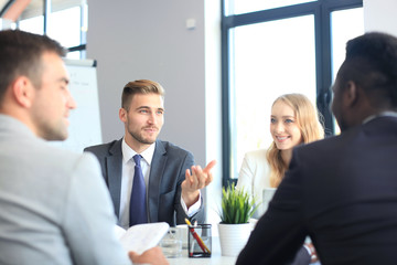 Wall Mural - Business people in discussing something while sitting together at the table.