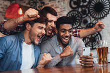 Men Watching Football On Smartphone In Bar