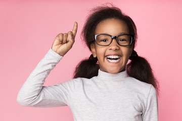 Happy kid in glasses having idea, raising finger