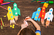 © ulza - preschool Child in creativity in the home. Happy kid makes rockets from paper. Children's creativity. Creative children play with craft.Tools and materials for children's art creativity on table.