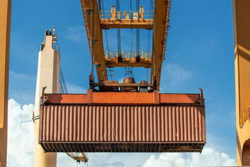 Wall Mural - Industrial port crane lift up loading export containers box onboard from truck at port of Thailand,The port crane type's twinlift is the best solution for port operations