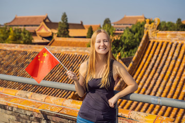 Wall Mural - Enjoying vacation in China. Young woman with national chinese flag in Forbidden City. Travel to China concept. Visa free transit 72 hours, 144 hours in China
