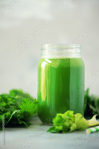 Bottle Of Green Celery Smoothie On Grey Concrete Background