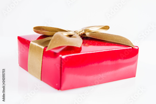 Fotografía Wrapped gift with a golden ribbon on a white background