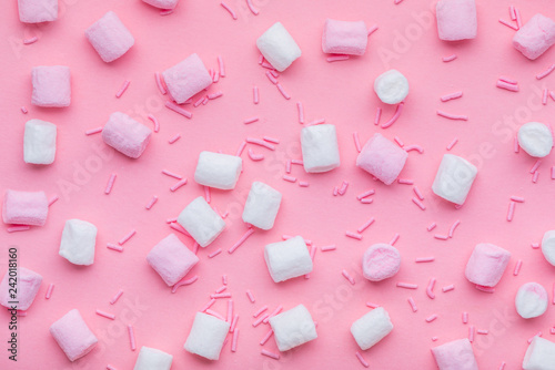 flat lay of sprinkles and marshmallow sweets on pink background, trendy pattern