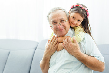 Wall Mural - The happy girl hugs a grandfather on the sofa