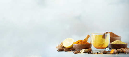 Canvas Print - Ingredients for turmeric hot tea on grey background. Healthy ayurvedic drink with lemon, ginger, cinnamon, turmeric. Immune boosting remedy