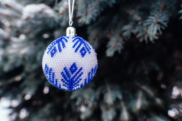 Wall Mural - Blue white christmas ball on fir tree branch close up