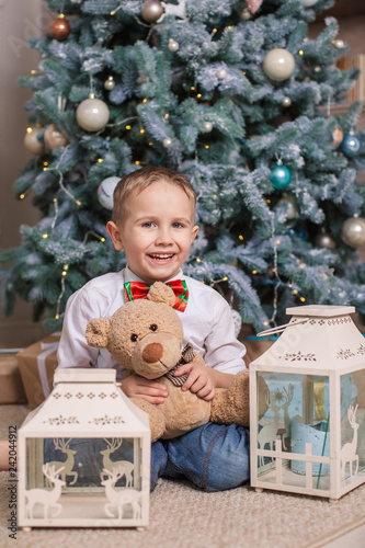Fotografie, Obraz Little boy under the Christmas tree with a toy