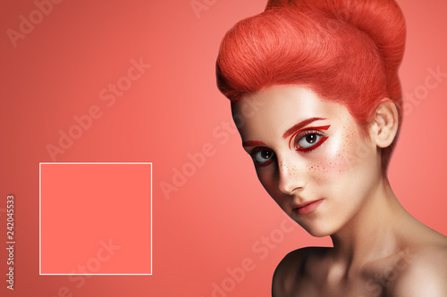 Fotografía Beautiful woman with hair colored in color of 2019 Living Coral on blue backgrou