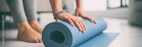 Fotomural Yoga at home active lifestyle woman rolling exercise mat in living room for morning meditation yoga banner background